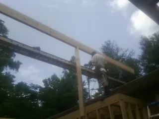 Carpenter setting a ridge beam over a new addition frame — Ice Dam Removal by Roofing Brothers in Lake Elmo