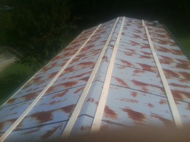 Rusted metal roof panels with new wood purlins before replacement — Storm Damage Roof Repair in Lake Elmo by Roofing Brothers