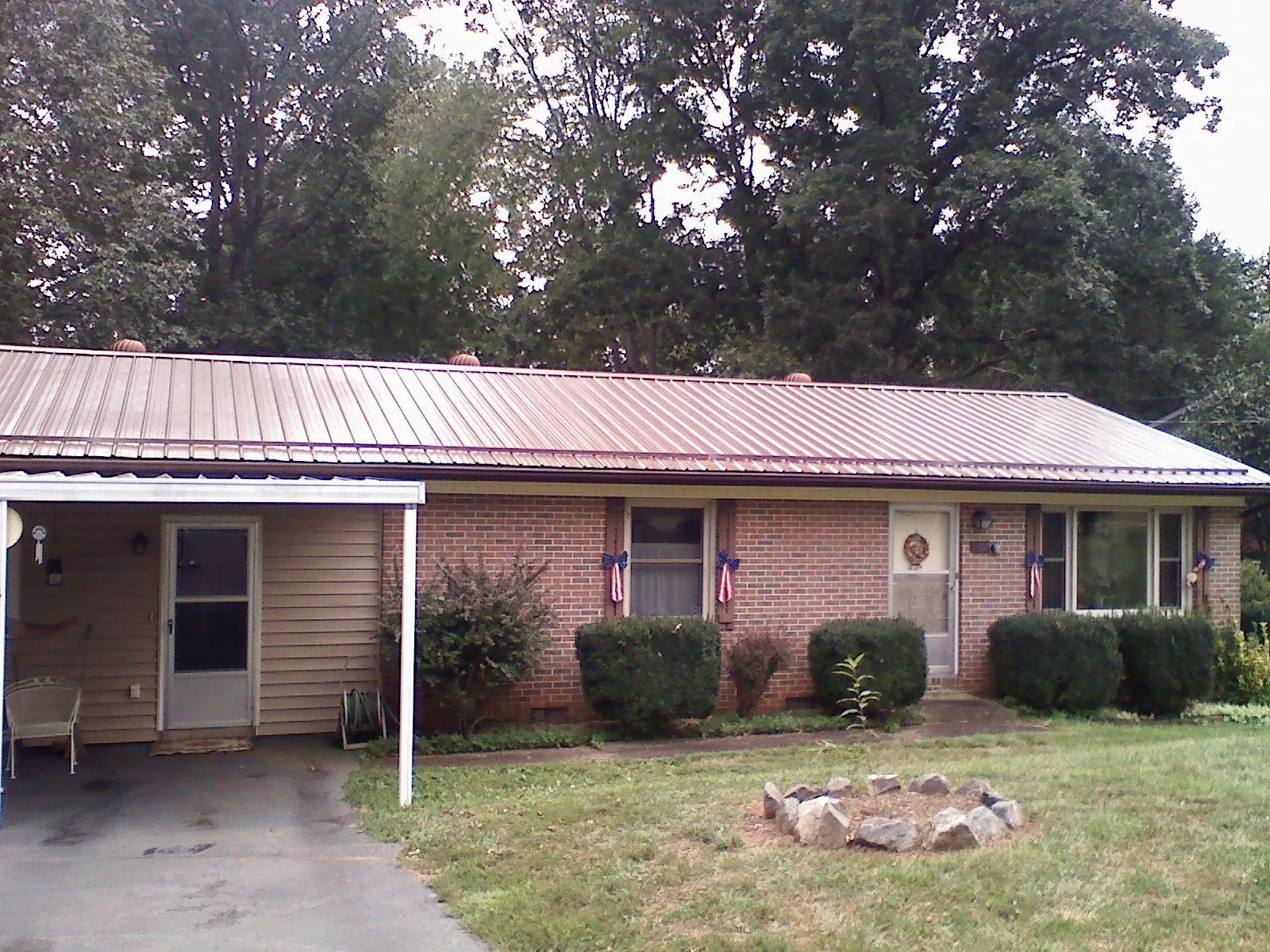 Bronze metal roof and carport on a brick ranch home — Roof Repair work by our crew in Lake Elmo
